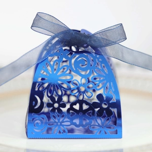 Detailed laser-cut blue wedding favor box with floral patterns and a matching blue ribbon