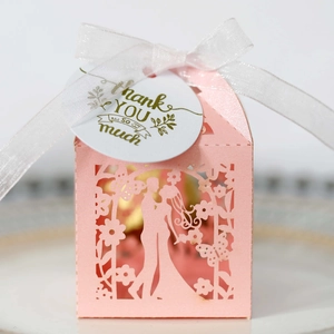 Detailed laser-cut hollow pink wedding favor box with Thank You tag and white organza ribbon