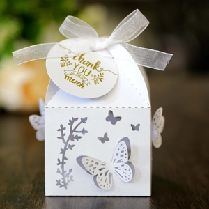 Close-up of white laser-cut butterfly gift box with silk ribbon and Thank You tag