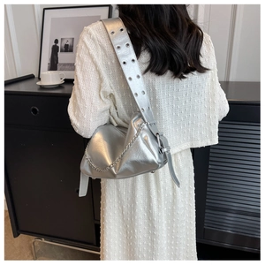 Detail of silver metallic shoulder bag featuring pleated texture and chain accents
