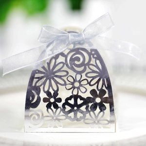 Macro shot of silver laser-cut wedding favor box with intricate floral and heart patterns