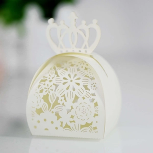 Detailed close-up of ivory laser-cut candy box with ornate crown and floral patterns