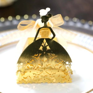 Macro detail of laser-cut wedding favors box featuring golden girl silhouette with ribbon