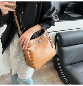 Detailed view of camel leather bucket bag with silver twist lock and strap