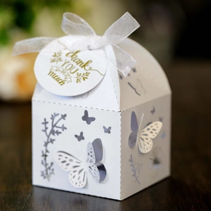Detailed view of white laser-cut butterfly gift box with silver ribbon and thank you tag
