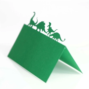 Détail de marque-places dinosaures verts découpés au laser pour décoration de table