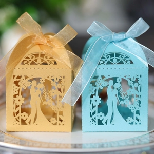 Detailed laser-cut wedding favor boxes in blue and gold with bride and groom silhouettes