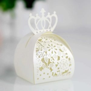 Close-up of white laser-cut candy box featuring hollow flower patterns and crown top