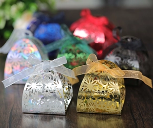 Laser-cut wedding favor boxes in various metallic colors with elegant organza ribbons