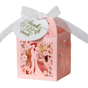 Pink laser-cut wedding favor box with butterfly motifs and a thank you tag