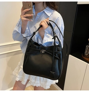 Close-up of black leather hobo bag featuring silver buckle and adjustable shoulder strap