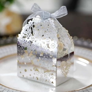 Laser-cut silver hollow candy box with floral patterns and a light blue silk ribbon