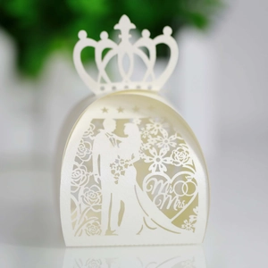 Detail of white laser-cut wedding favor box with Mr & Mrs silhouette and crown top