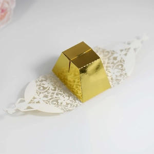 Detail of mirror gold laser-cut candy box with white hollow floral angel pattern