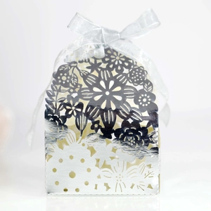 Detailed laser-cut silver candy box with intricate floral pattern and matching ribbon bow