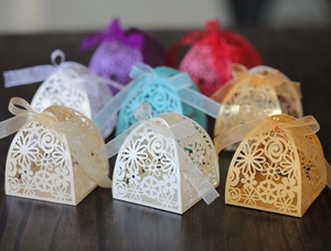 Detail of laser-cut wedding favors with intricate floral patterns and organza ribbons