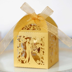 Detailed laser-cut gold wedding candy box featuring a couple silhouette and ribbon bow