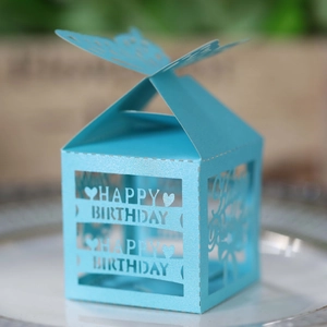 Macro shot of light blue laser-cut paper gift box with butterfly closure and heart pattern