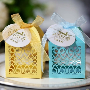 Detail of laser-cut European wedding favor boxes with Thank You tags and organza ribbons