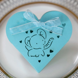Dettaglio scatola regalo azzurra a cuore con elefantino e decorazioni a cuore traforate