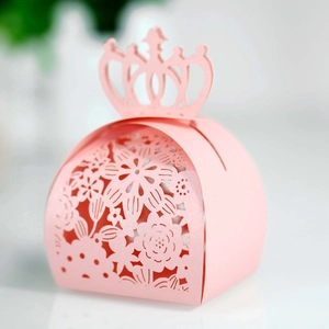 Macro shot of pink laser-cut crown candy box with intricate floral hollowed patterns