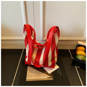 Détail du sac cabas en maille à rayures rouges et blanches avec texture ajourée
