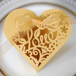 Detailed laser-cut heart favor box in gold with Love text and ribbon for weddings