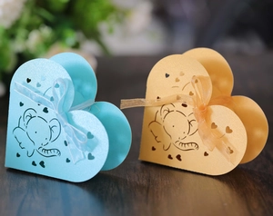 Dettaglio di scatole regalo a forma di elefante blu e oro con cuori e fiocchi in organza