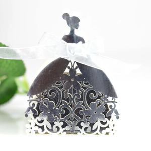 Macro view of laser-cut silver wedding favor box with floral patterns and a white bow