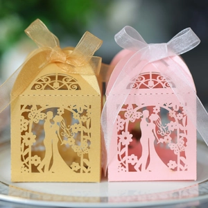 Laser-cut wedding favor boxes in gold and pink with bride and groom silhouette and ribbon