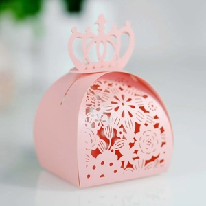 Close-up of a pink hollow candy box with an elegant laser-cut crown handle and floral details