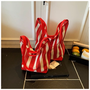 Vue détaillée des sacs seaux en maille rayée rouge et blanc avec anses en cuir souple