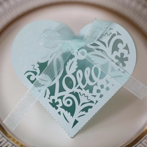 Detail of light blue heart-shaped laser-cut gift box with Love text and ribbon bow