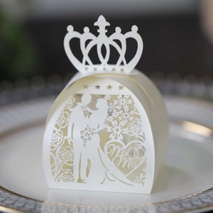 Macro detail of laser cut wedding favor box with Mr & Mrs silhouette and crown pattern
