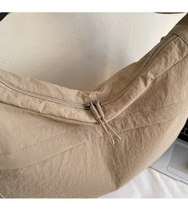 Gros plan sur les doubles fermetures éclair métalliques et le tissu en nylon du sac
