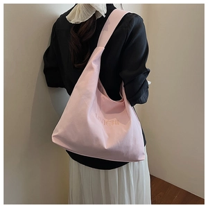 Close-up of pink canvas tote bag with MWICHI embroidery and wide shoulder strap