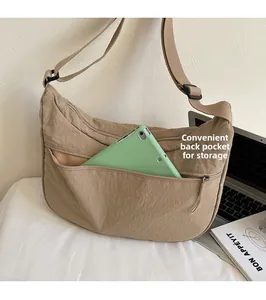 Détail du sac croissant en nylon kaki montrant la poche zippée pour ranger une tablette