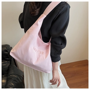 Close-up of pink canvas hobo bag featuring detailed MVICHI embroidery and wide shoulder strap