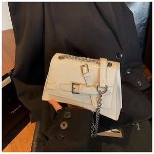 Detail of a creamy white leather mini crossbody bag featuring stylish silver chain straps