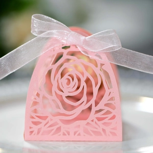 Dettaglio della scatola regalo rosa intagliata al laser con elegante fiocco in chiffon
