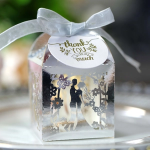 Detail of silver laser-cut wedding candy box with blue ribbon and thank you tag
