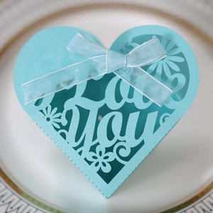 Close-up of heart-shaped blue gift box with I LOVE YOU laser cut hollow pattern