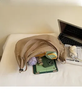 Intérieur spacieux du sac croissant en nylon kaki contenant une tablette et un parapluie