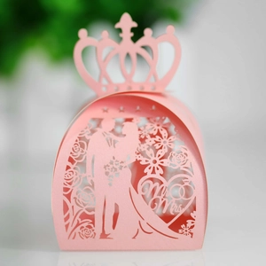 Macro shot of laser-cut crown wedding candy box with bride and groom silhouette