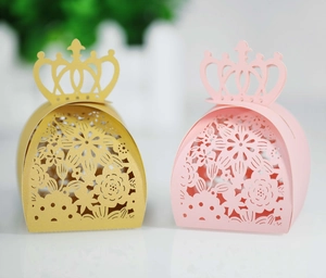 Detail of laser-cut gift boxes with floral patterns and crown top in gold and pink