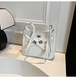Detail view of large white hobo bag with silver buckle straps and a twist-lock closure