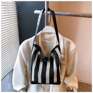 Détail du sac fourre-tout en maille rayée noire et blanche avec poignées en cuir