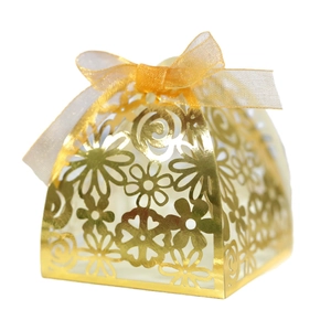 Elegant gold laser-cut favor box with floral patterns and a sheer ribbon bow for weddings