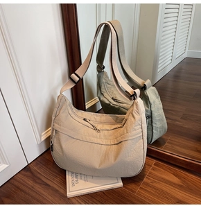 Détail du sac bandoulière croissant beige avec texture plissée et sangle réglable