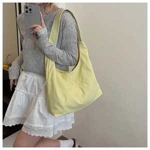 Mirror selfie showing large yellow nylon tote bag with MVICHI embroidery detail